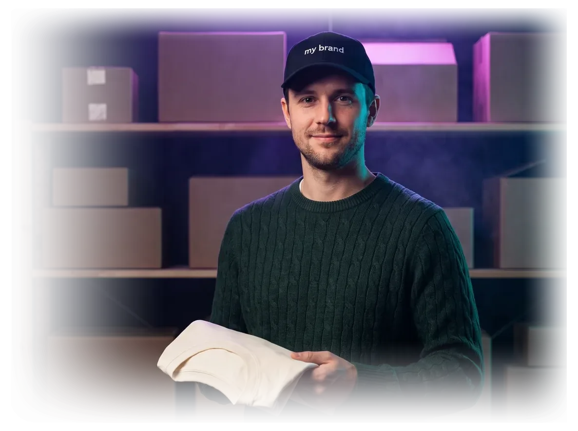 Inhaber einer kleinen Marke mit Cap seiner eigenen Marke, hält ein T-Shirt, vor Versandregalen